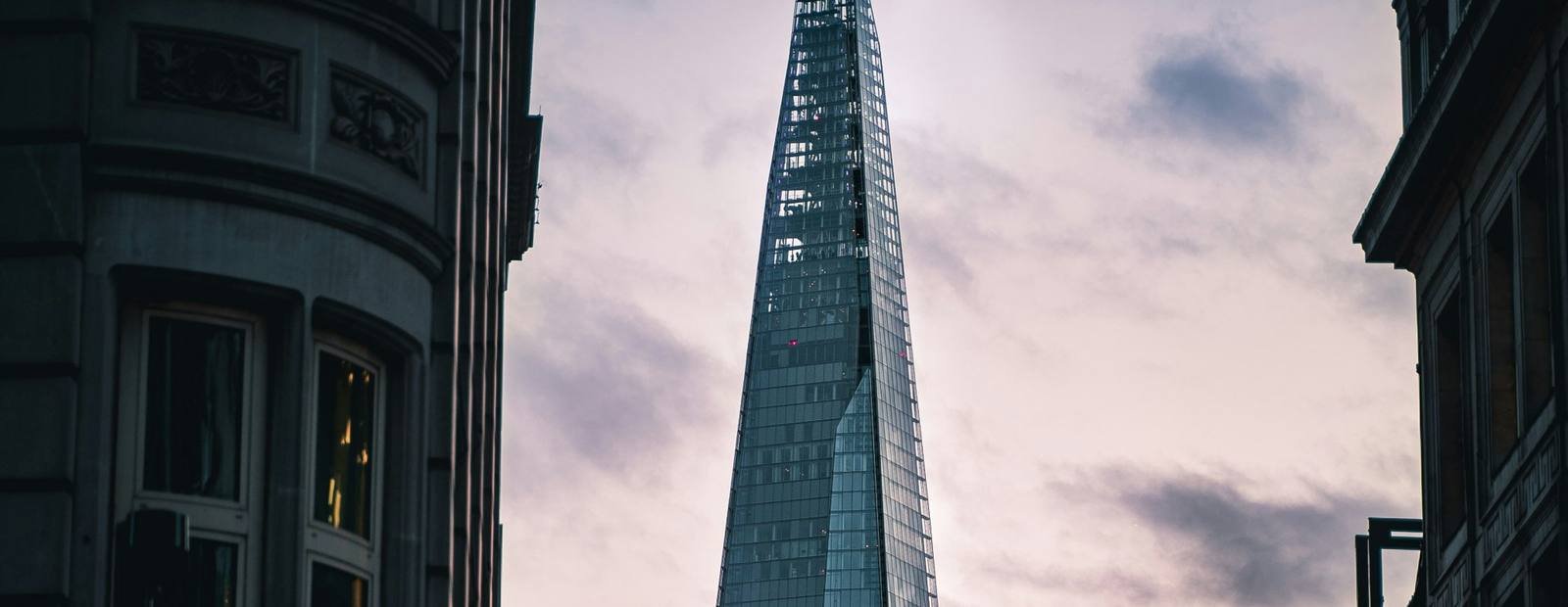 Glass tower rising between London buildings